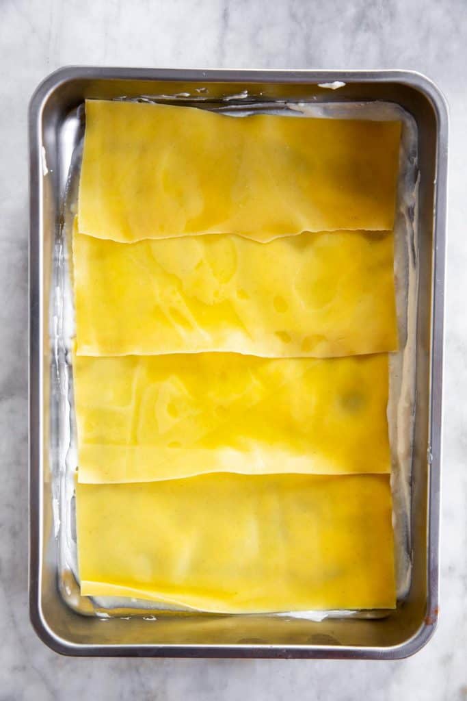 casserole dish with béchamel sauce and lasagna sheets