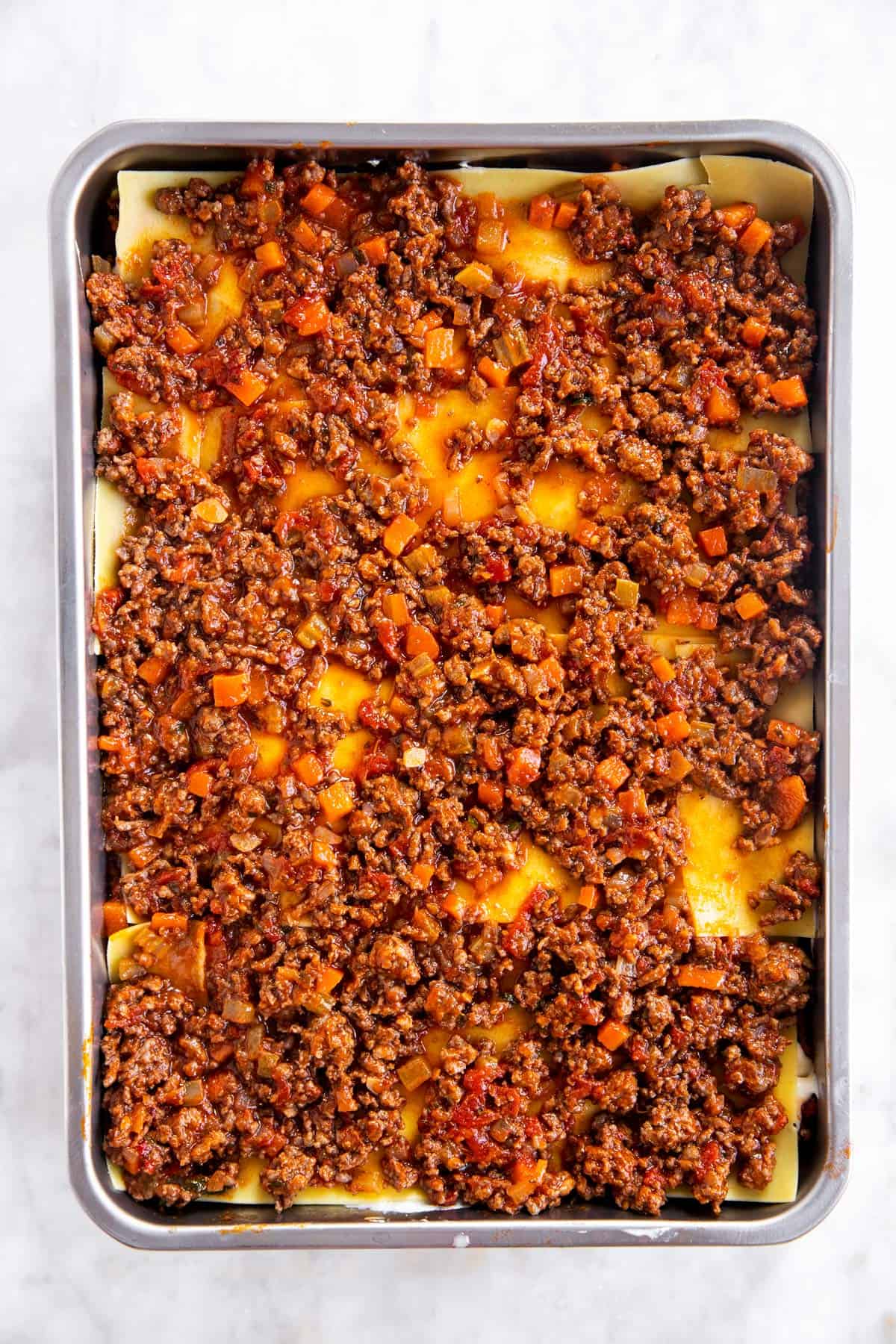 casserole dish with third layer of bolognese sauce