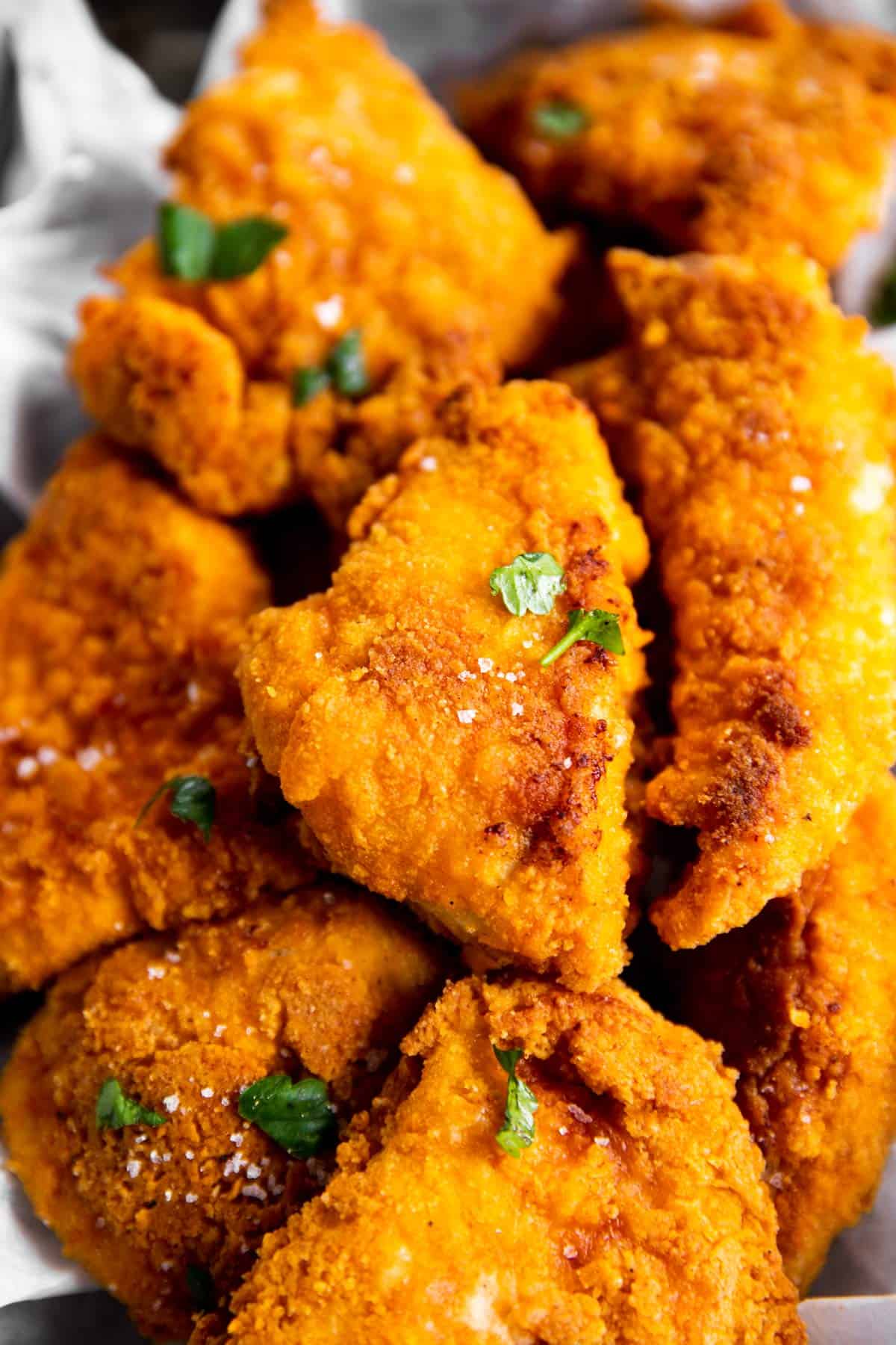 pile of oven fried chicken in parchment lined basket