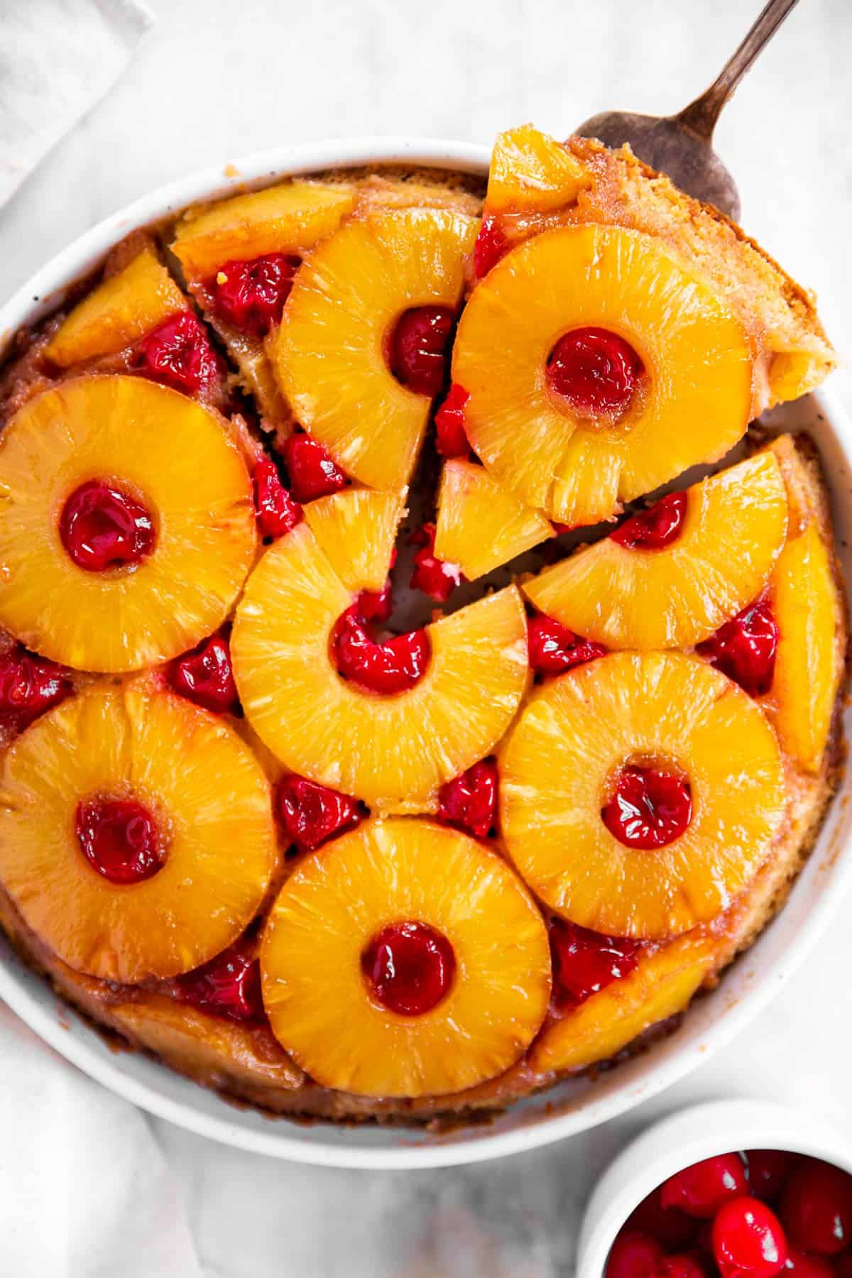 close up photo of pineapple upside down cake with slices cut