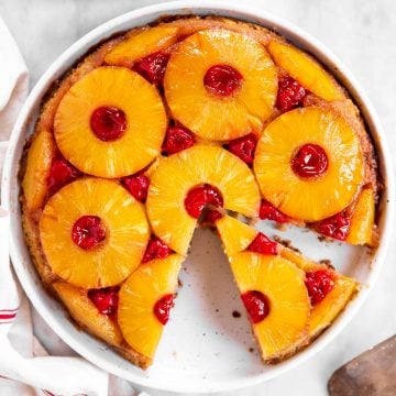 overhead view of sliced pineapple upside down cake on marble surface