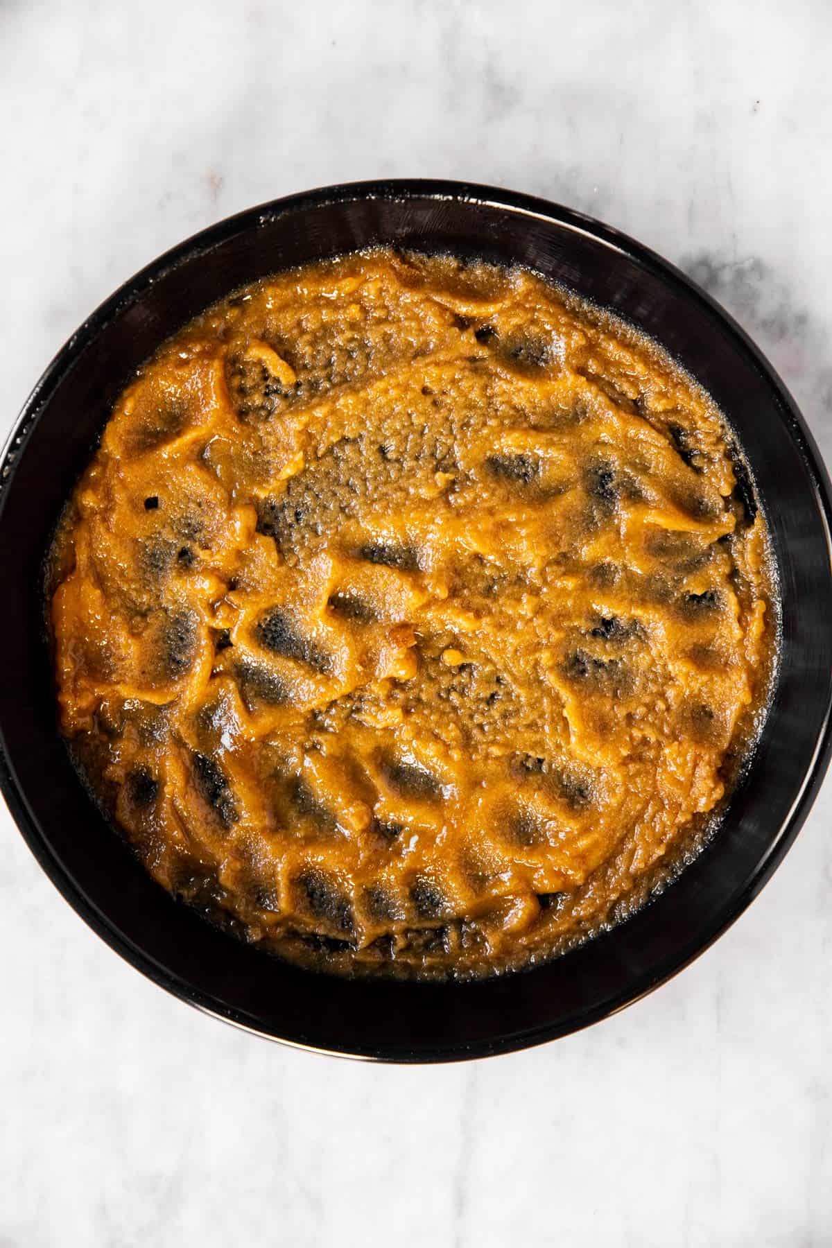 brown sugar and butter paste spread in black cake pan