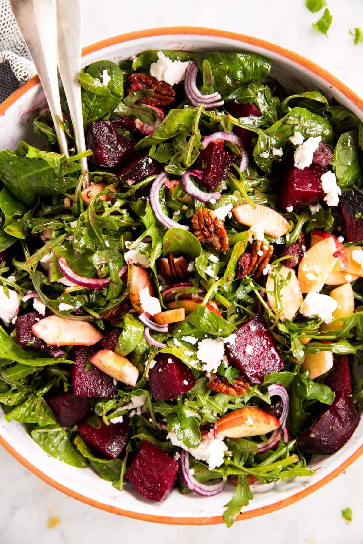 overhead close up photo of roasted beet salad with goat's cheese in large salad bowl