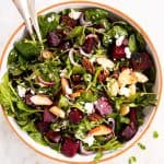 overhead photo of roasted beet salad with goat's cheese in large salad bowl
