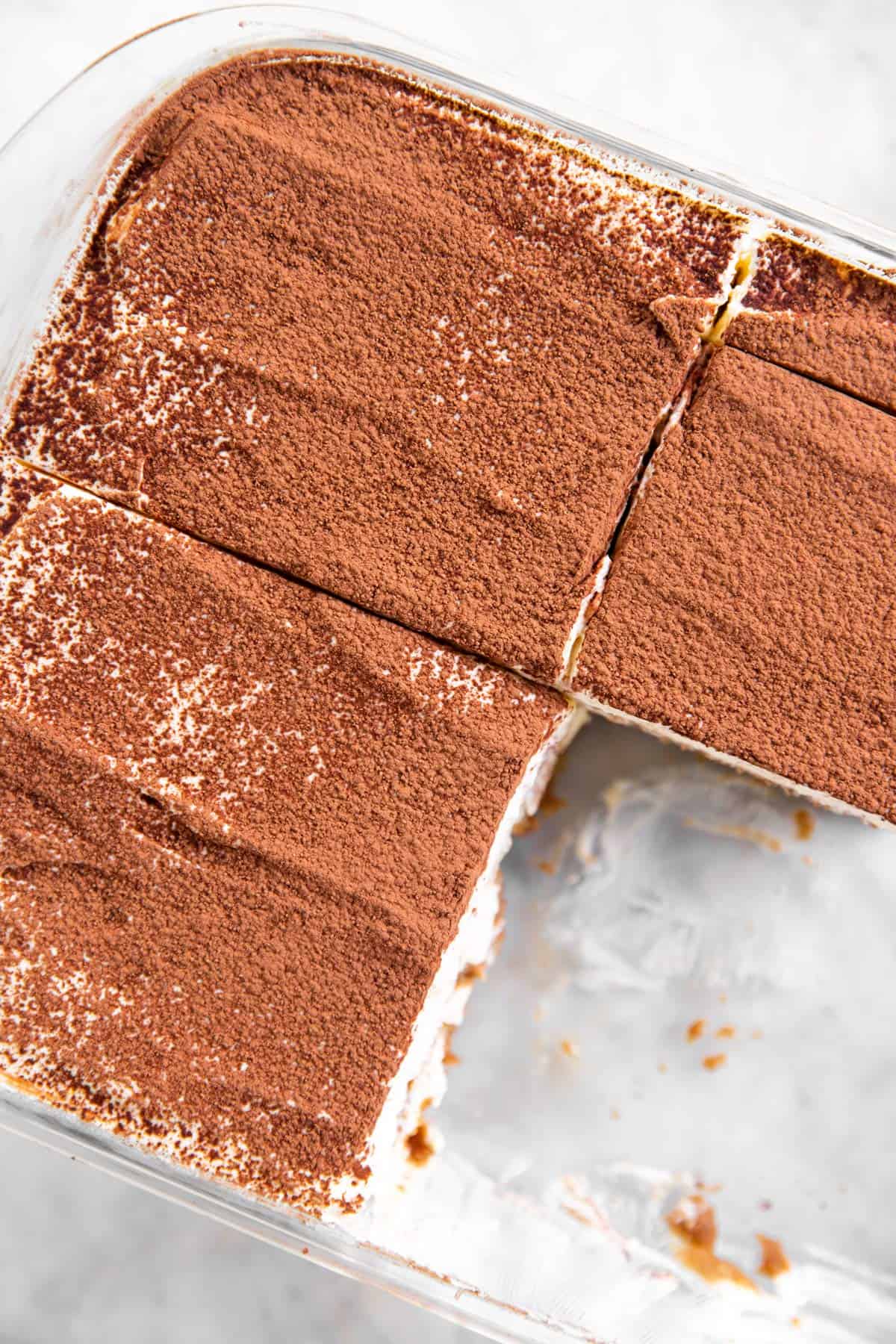 overhead view of sliced tiramisu in glass pan