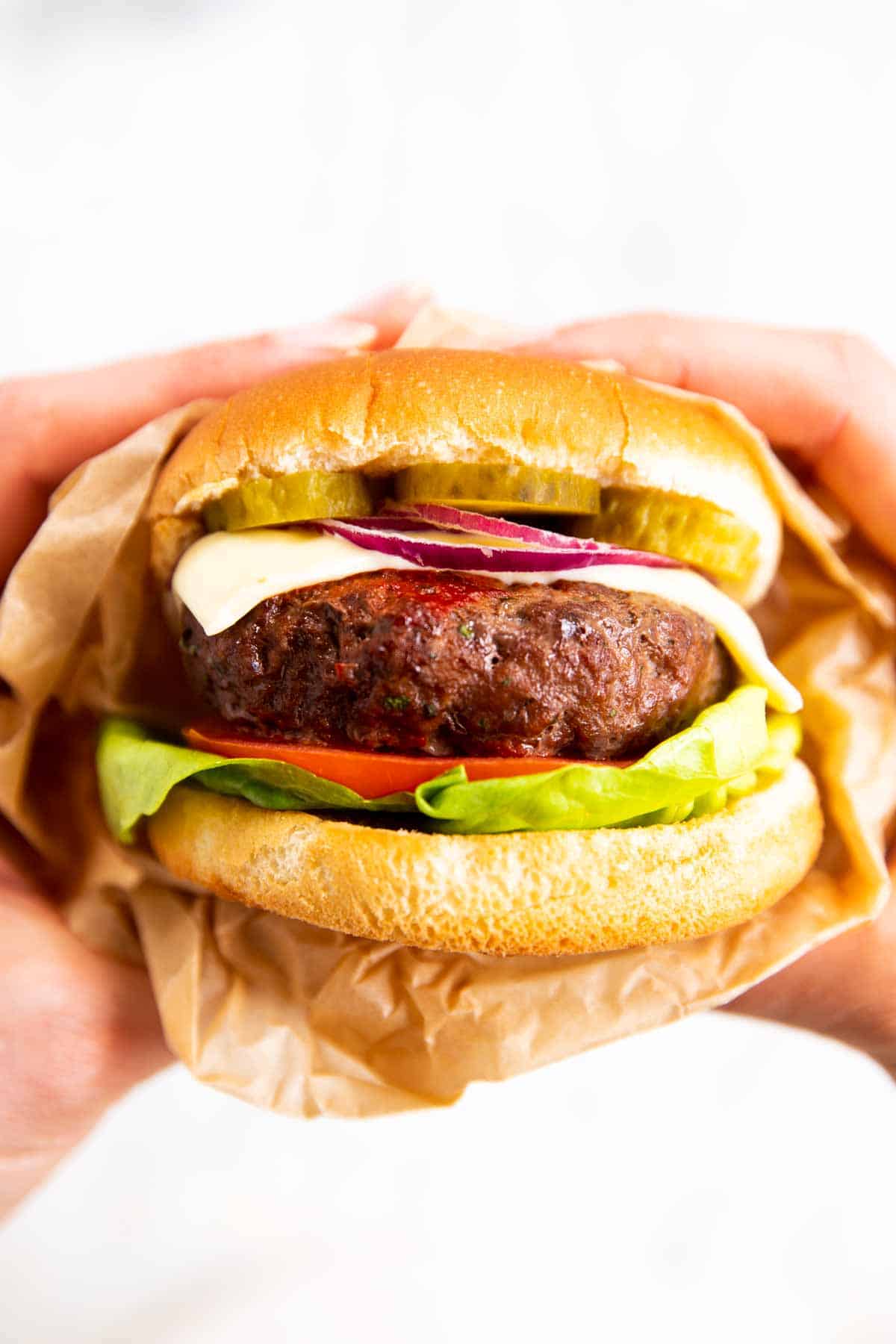 female hands holding burger with air fried patty