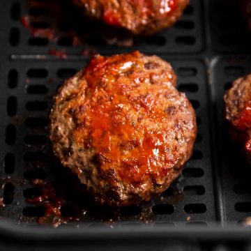 close up photo of air fryer burger patty in air fryer basket