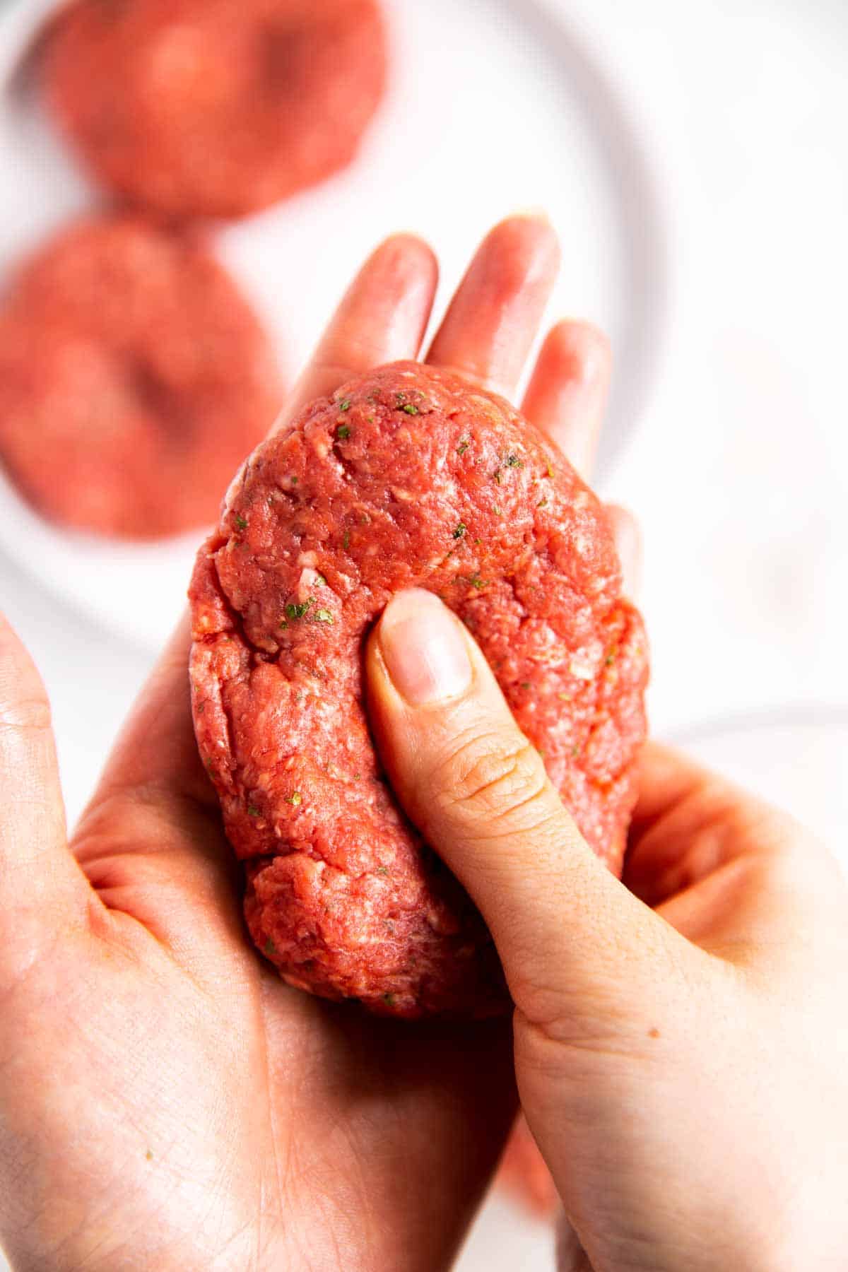 female hands shaping burger patty