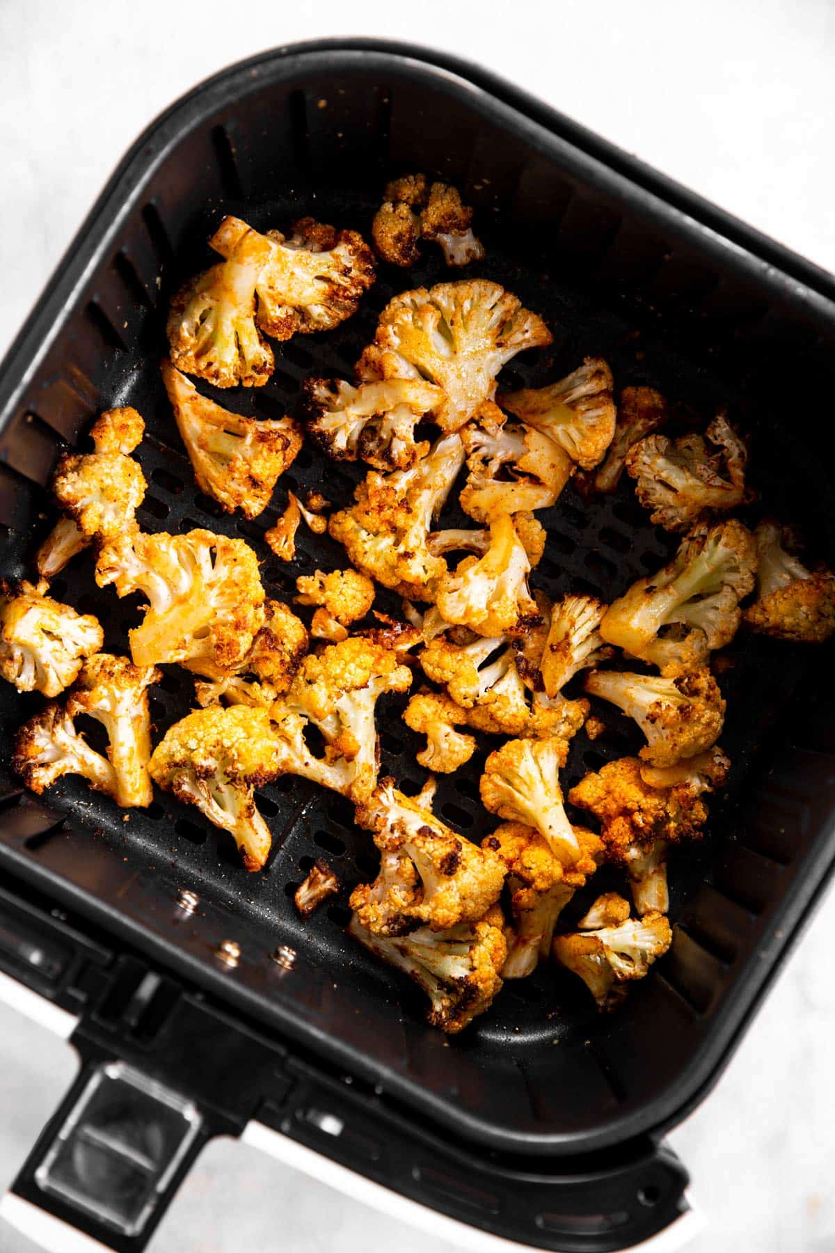 overhead view of air fried cauliflower in air fryer basket