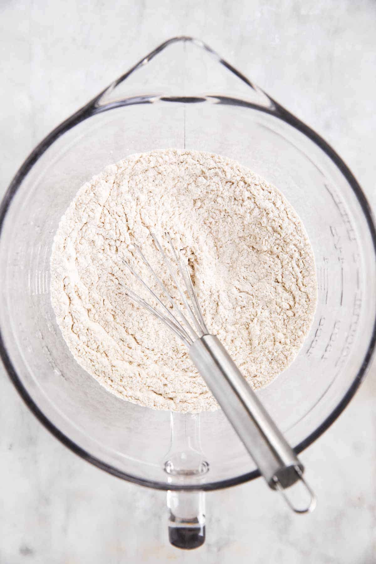 dry ingredients for banana bread in glass bowl with whisk