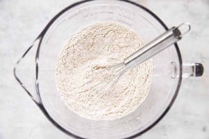 dry ingredients for banana bread in glass bowl with whisk