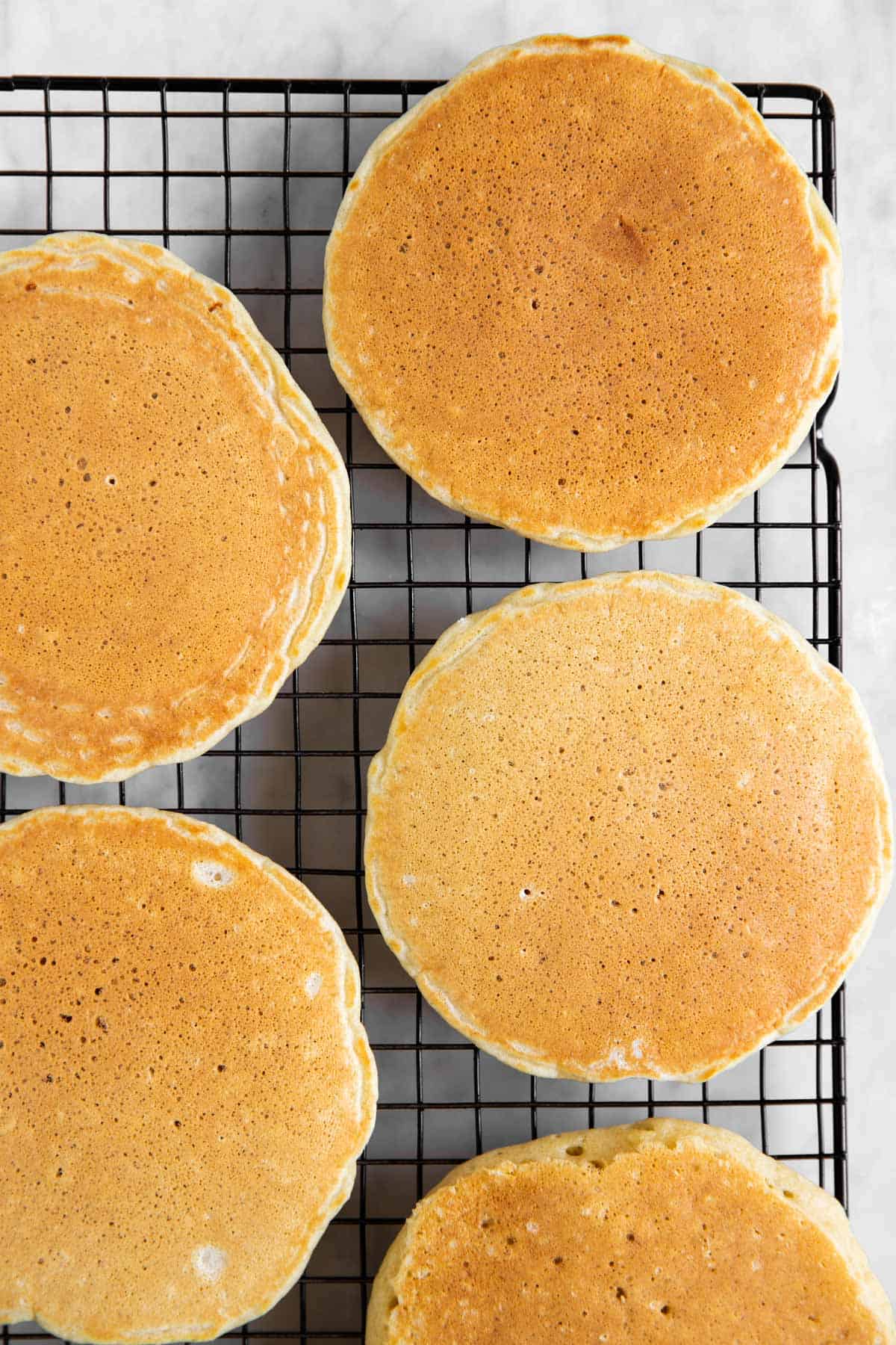 five buttermilk pancakes on black cooling rack
