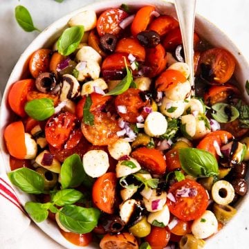 overhead view of white bowl filled with cherry tomato salad