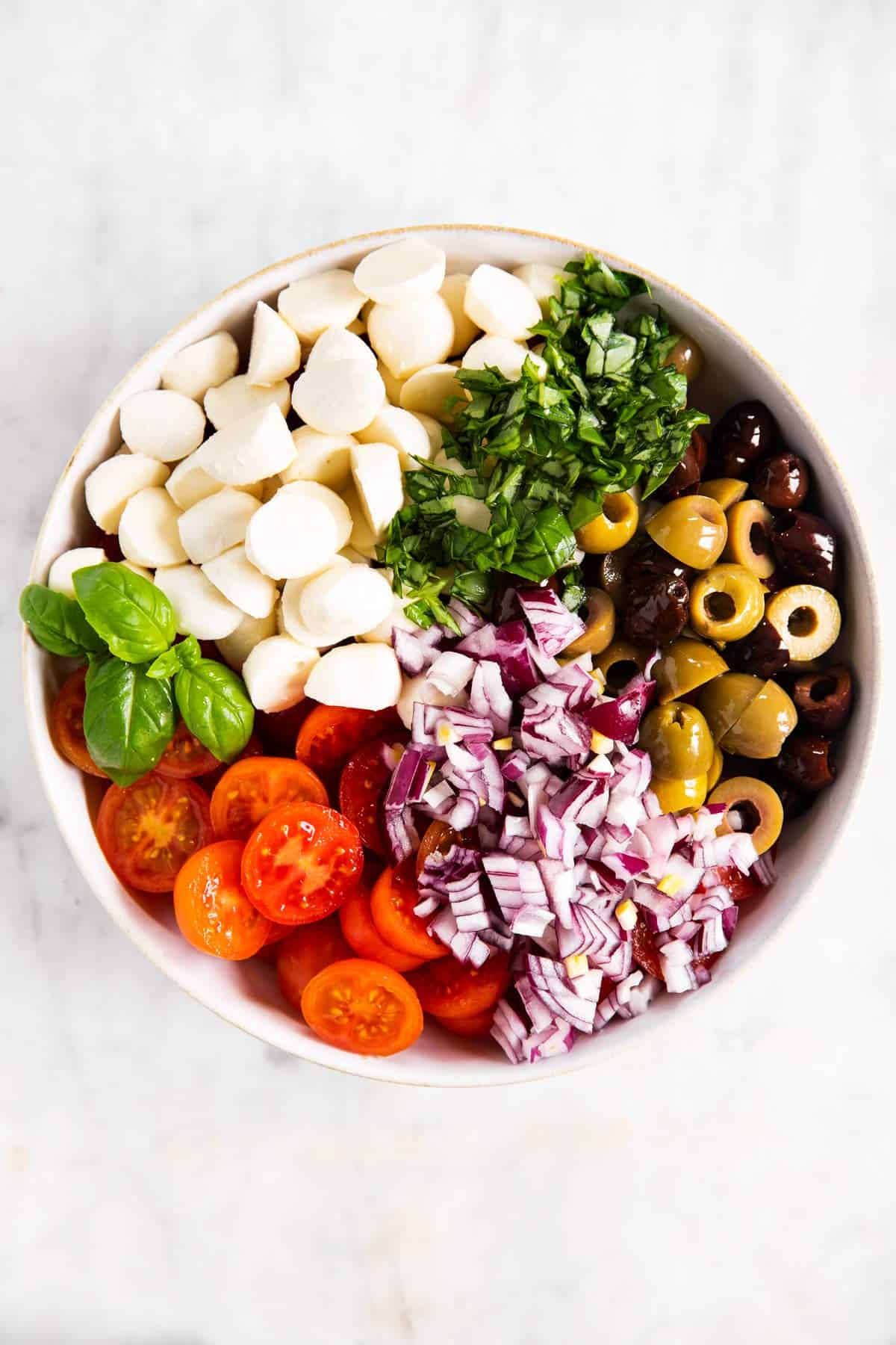 ingredients for cherry tomato salad in white bowl