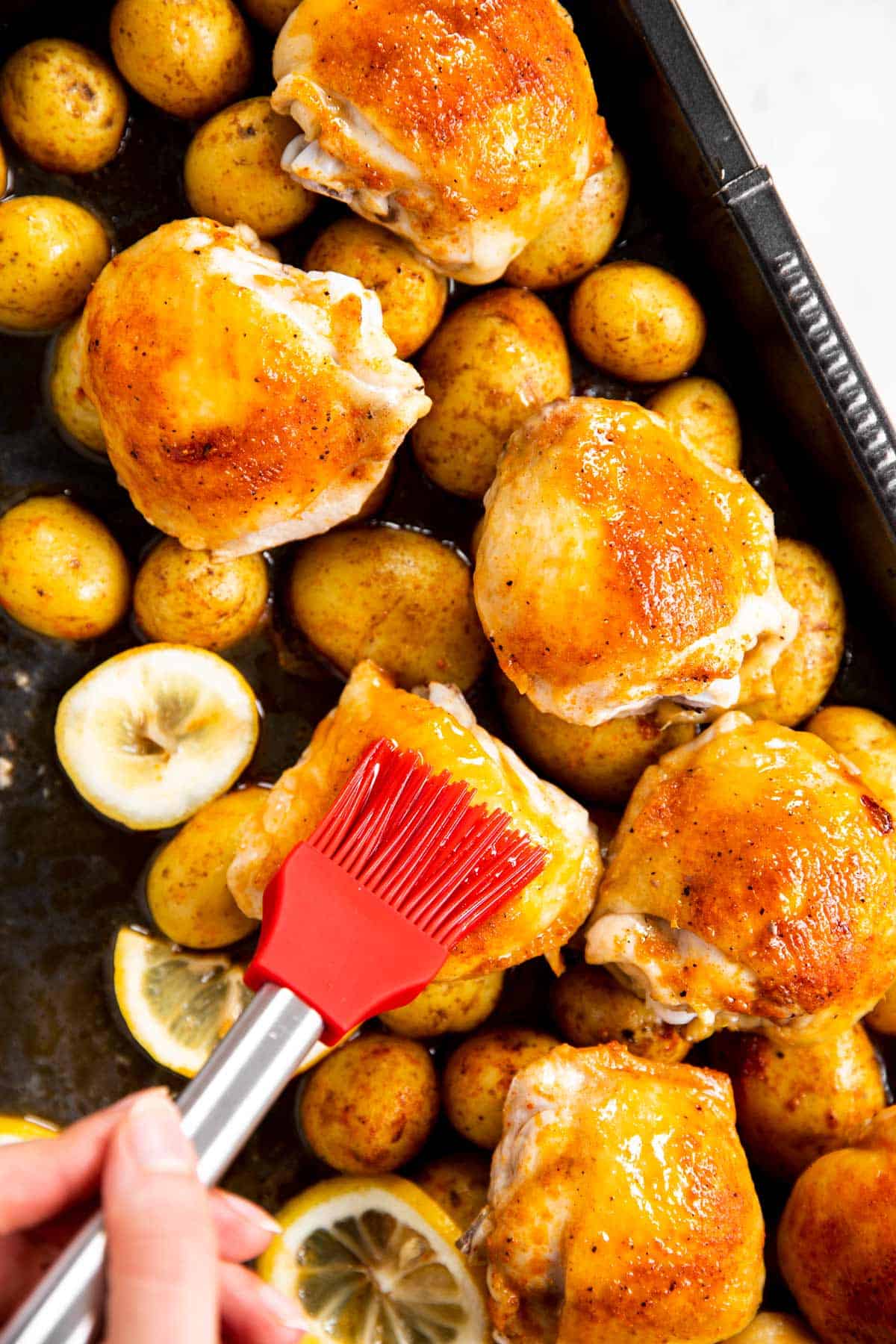 basting chicken thighs with red pastry brush