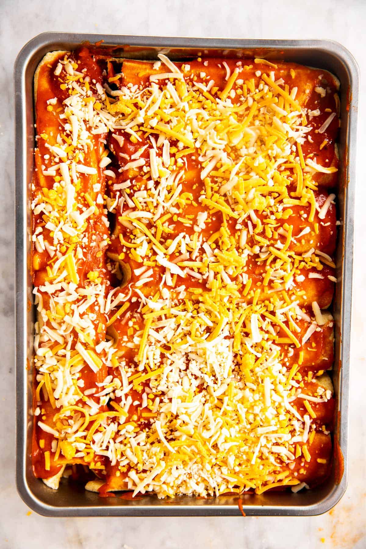 unbaked chicken enchiladas in casserole dish