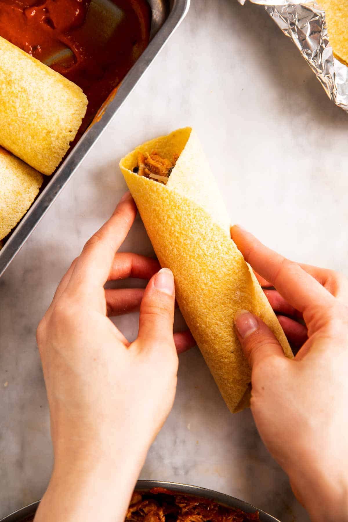female hand holding folded corn tortilla
