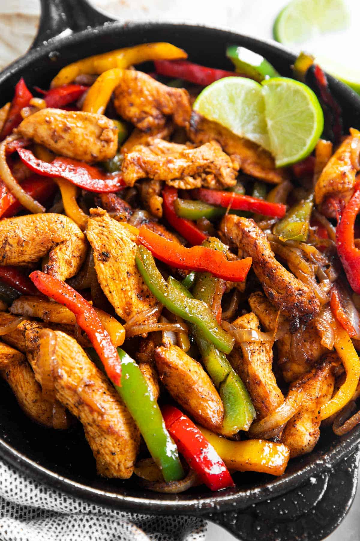 close up photo of chicken fajita filling in black cast iron skillet