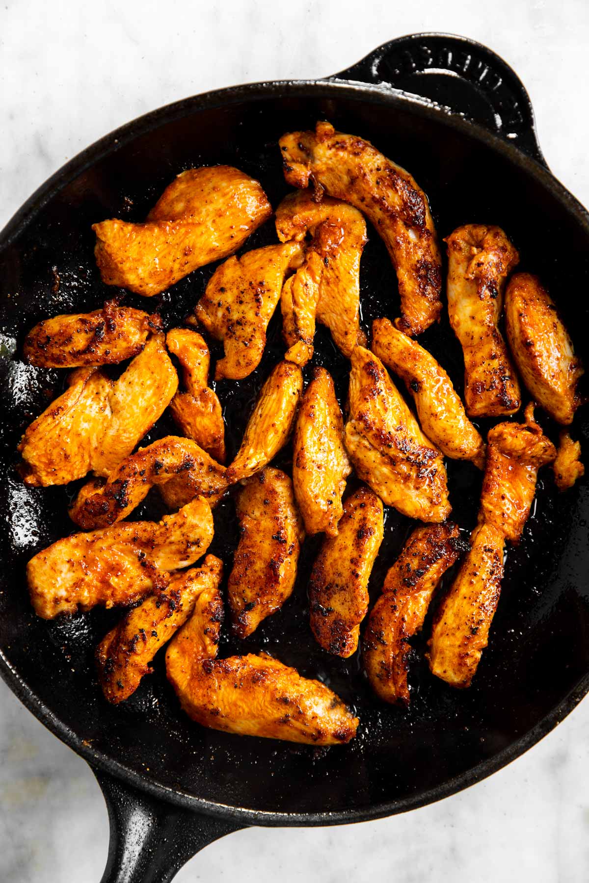 browned chicken strips in black cast iron skillet