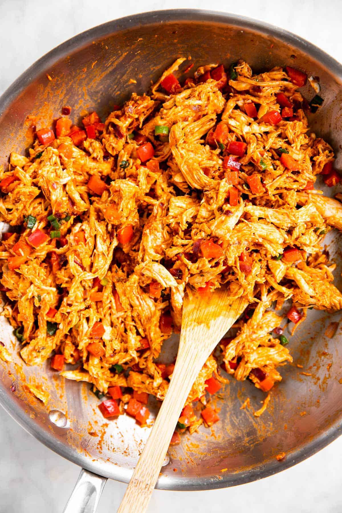 chicken quesadilla filling in skillet with wooden spoon