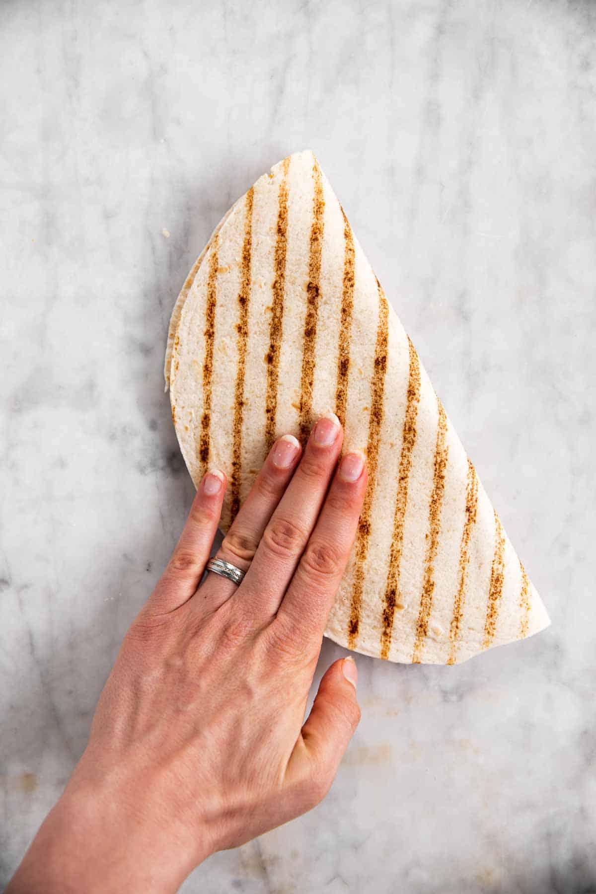 female hand folding tortilla wrap in half