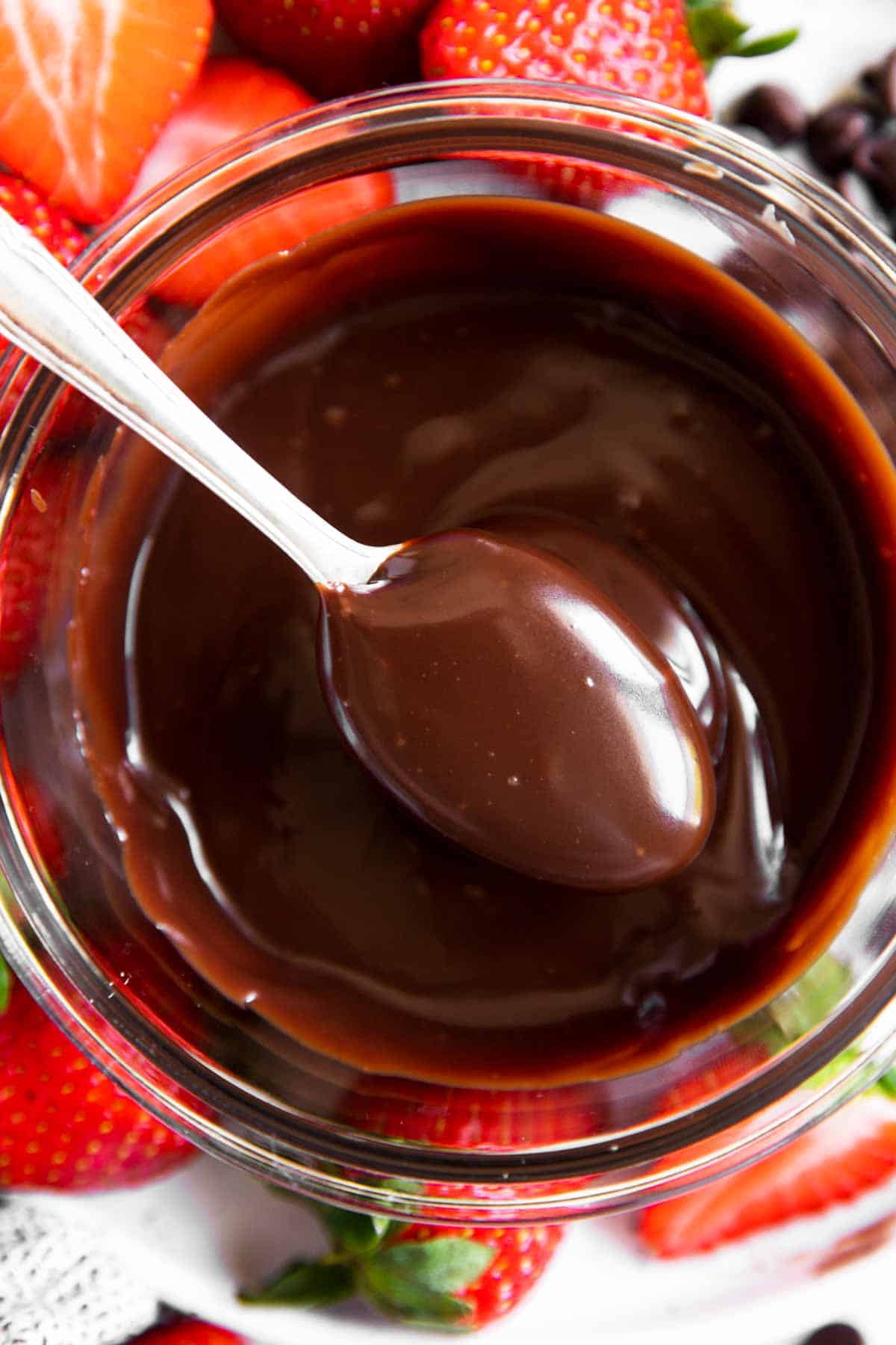 overhead view of spooning chocolate sauce from glass bowl