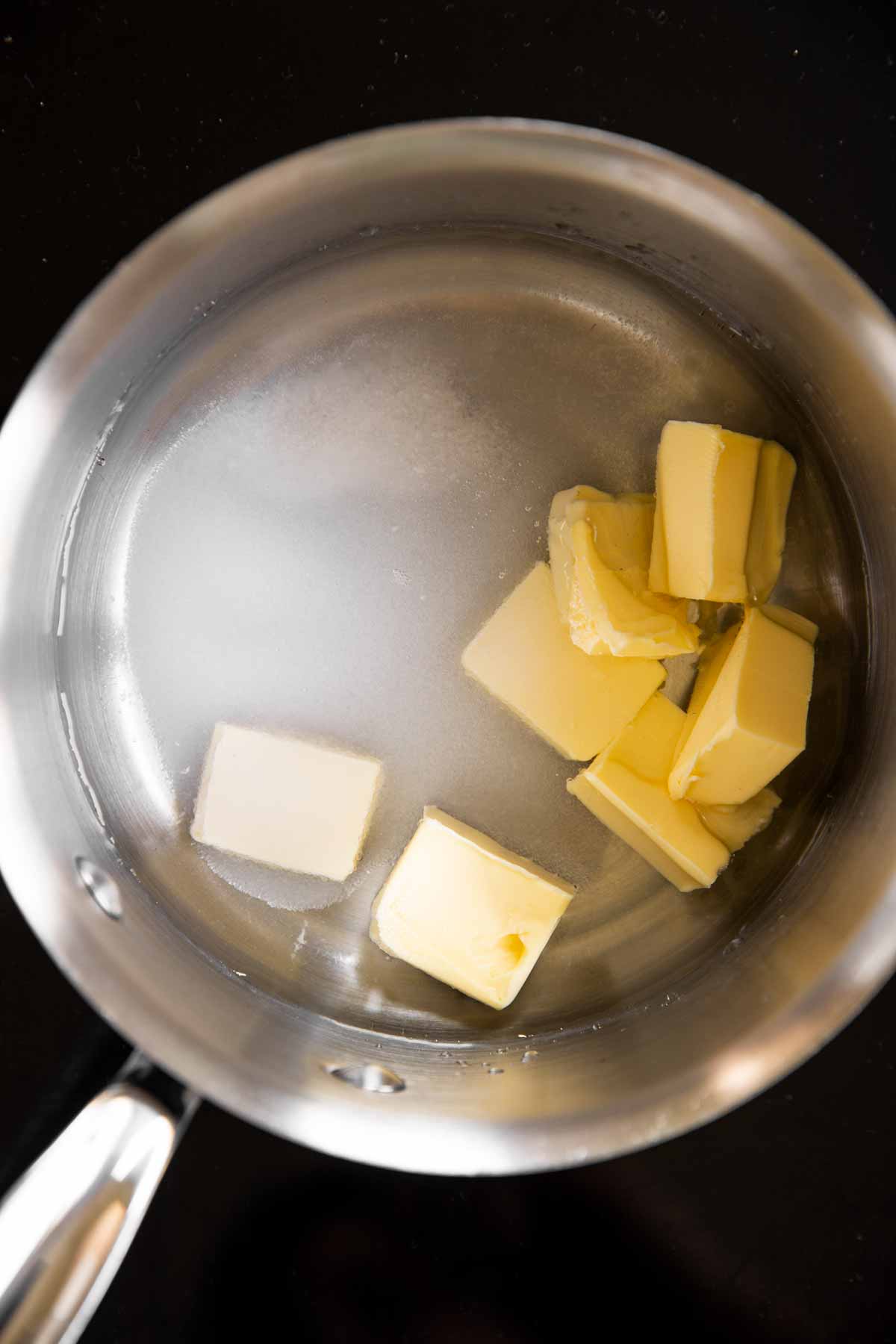 water with diced butter and sugar in saucepan
