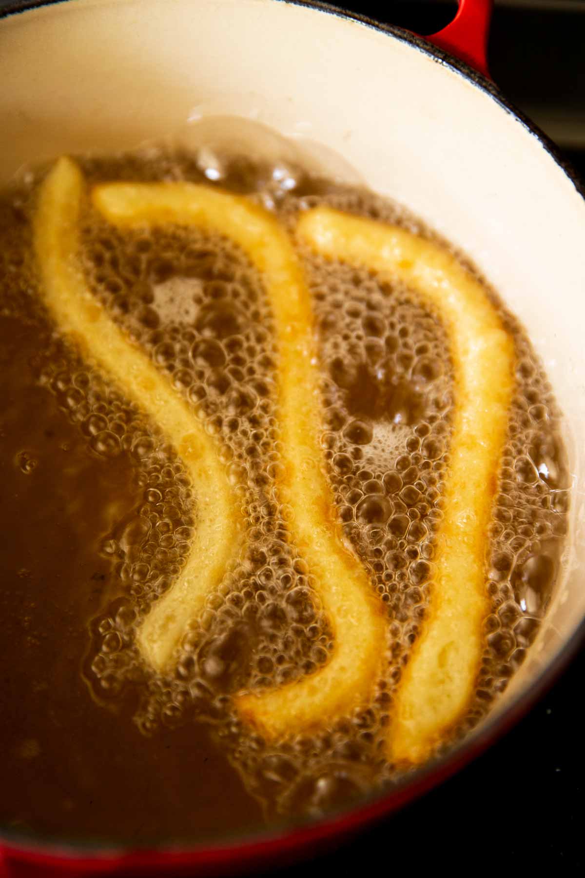 churros in hot oil, ready to be flipped