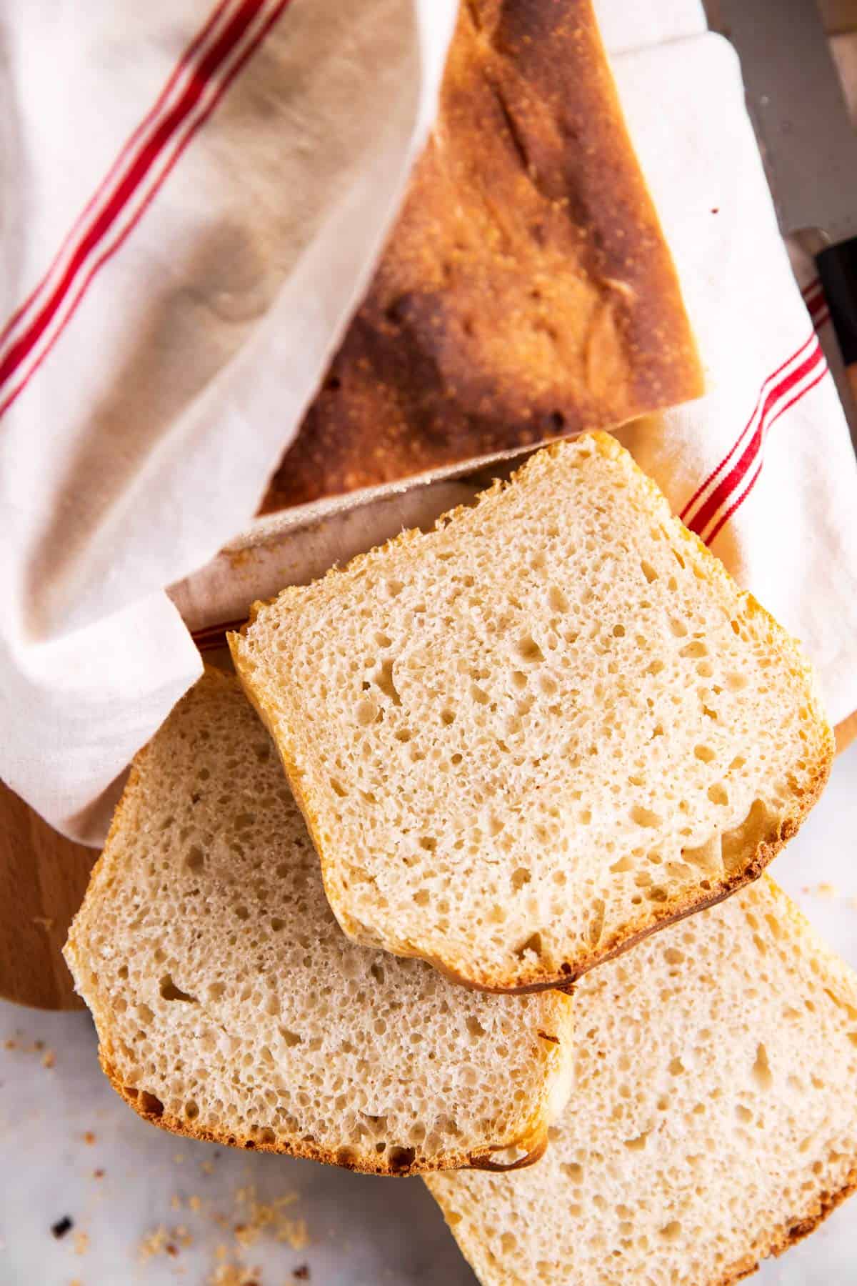 overhead view of sourdough bread loaf with three slices sliced off