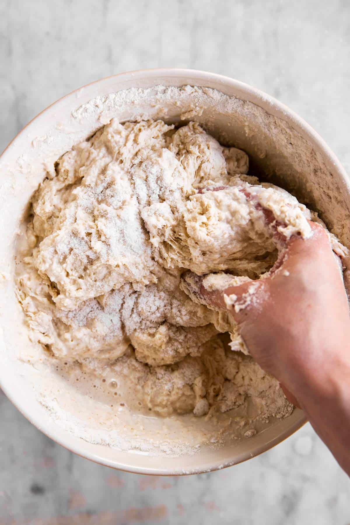 female hand stirring sourdough bread dough