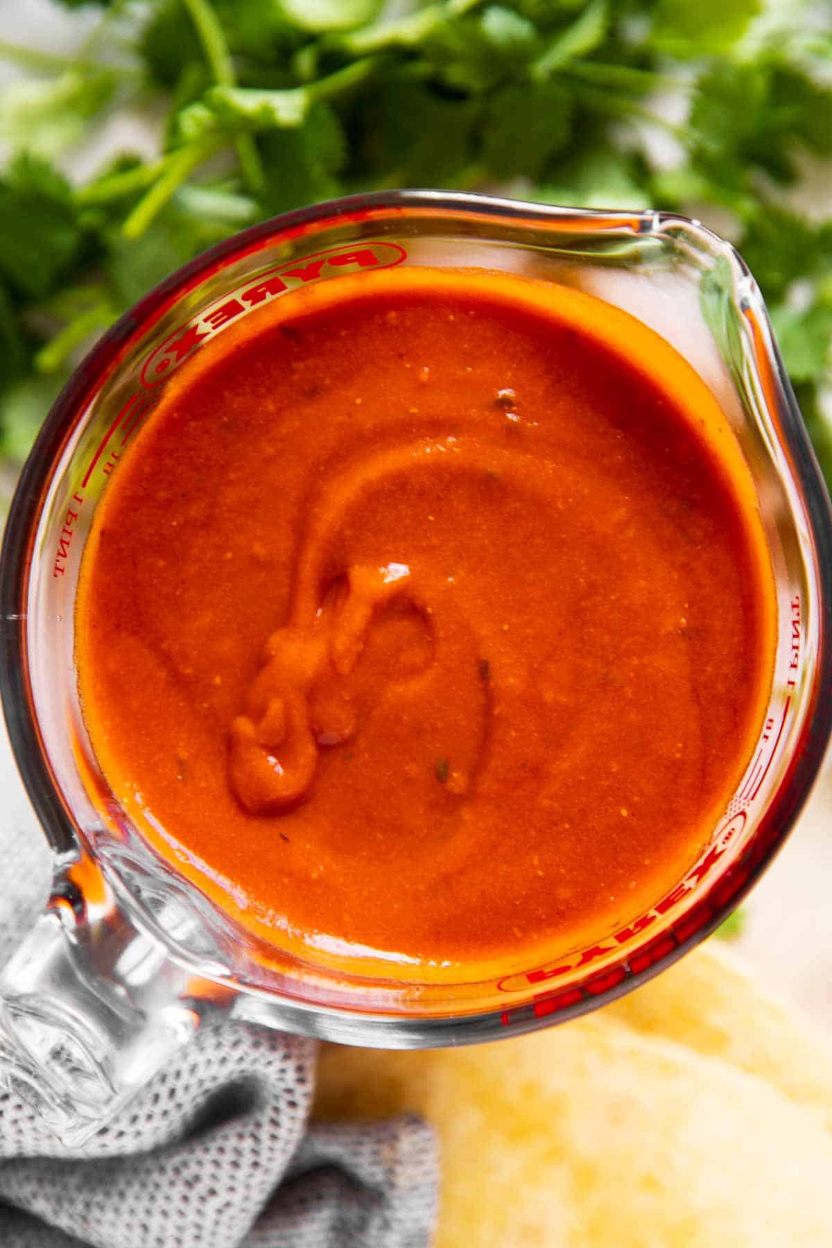 overhead view of enchilada sauce in glass measuring jug