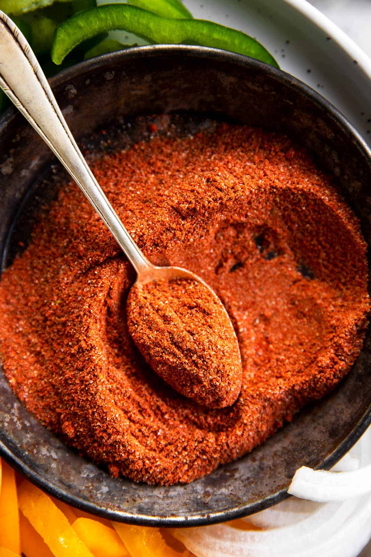 homemade fajita seasoning in black metal dish with spoon