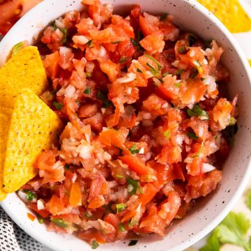 white bowl with chips and fresh salsa inside