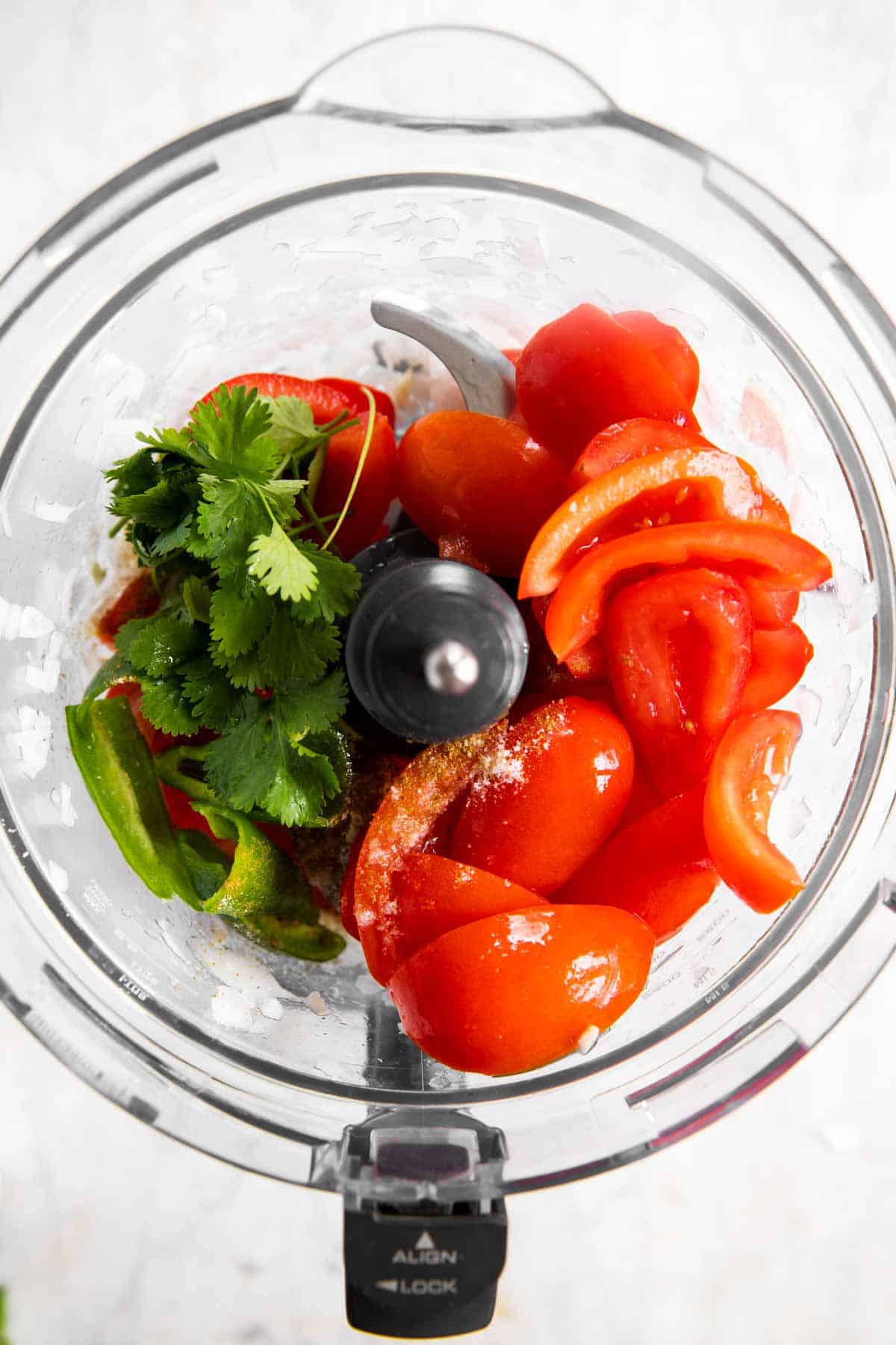 cilantro and tomatoes in food processor bowl