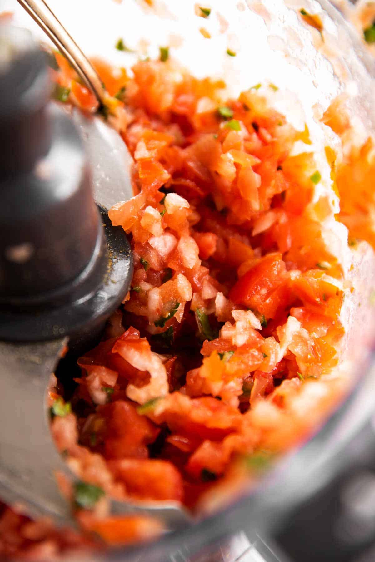 close up photo of fresh salsa in food processor bowl