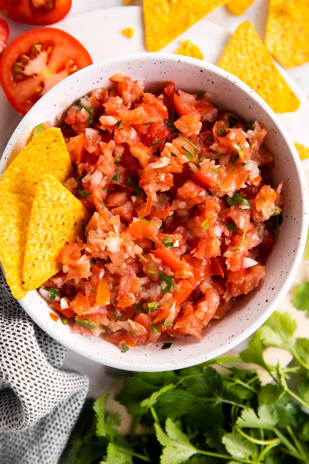 white bowl with chips and fresh salsa inside