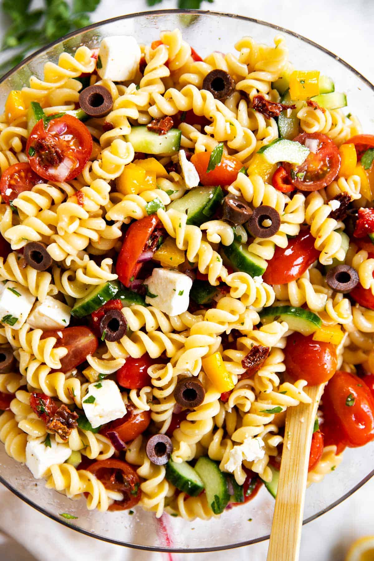 overhead view of greek pasta salad in glass bowl