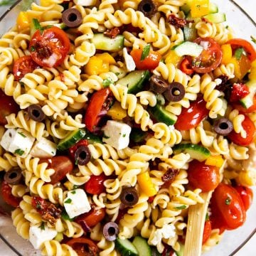 overhead view of greek pasta salad in glass bowl