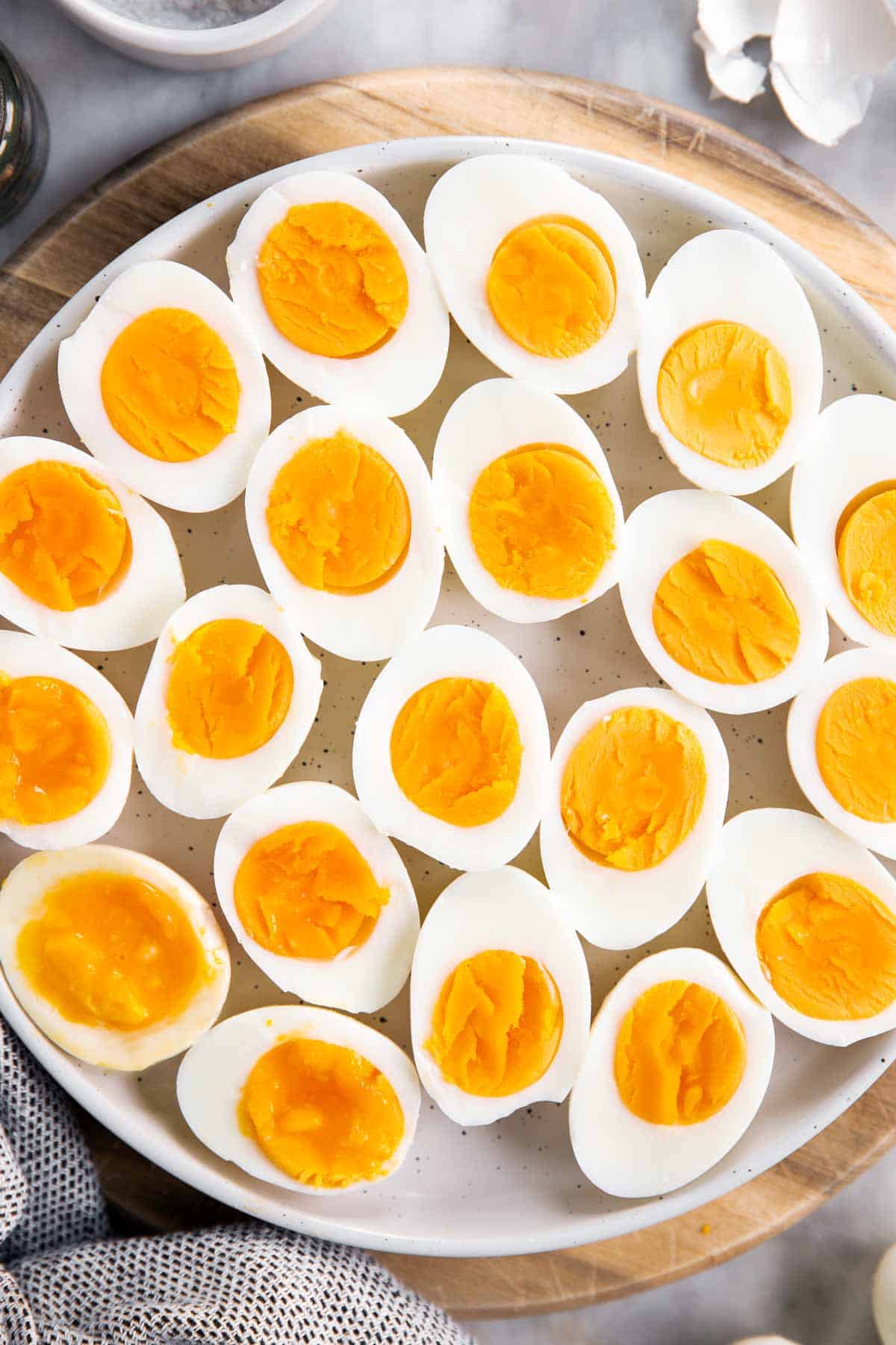 overhead closeup of white platter with hard boiled eggs cut in halves