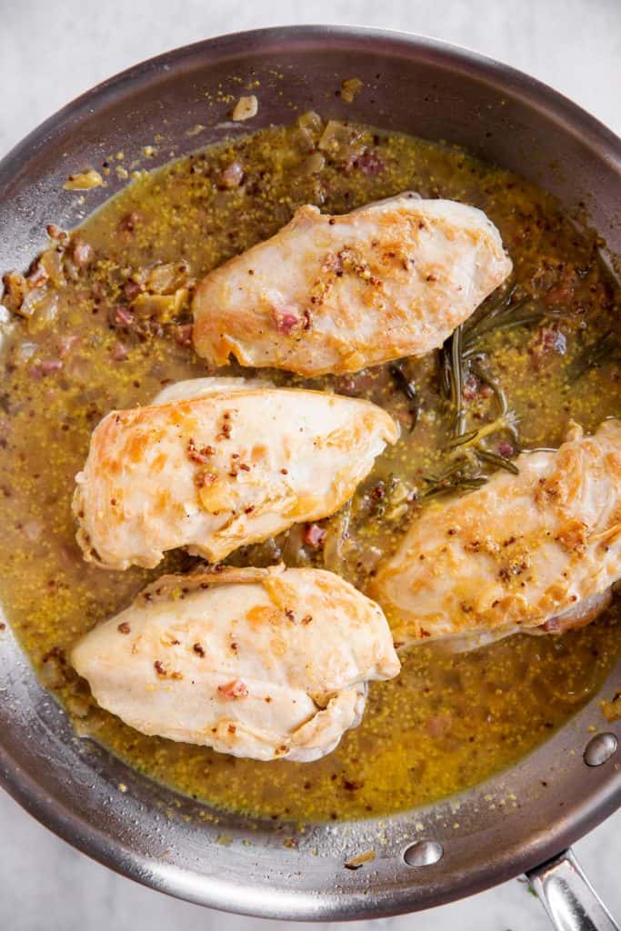 cooked honey mustard chicken in stainless steel skillet