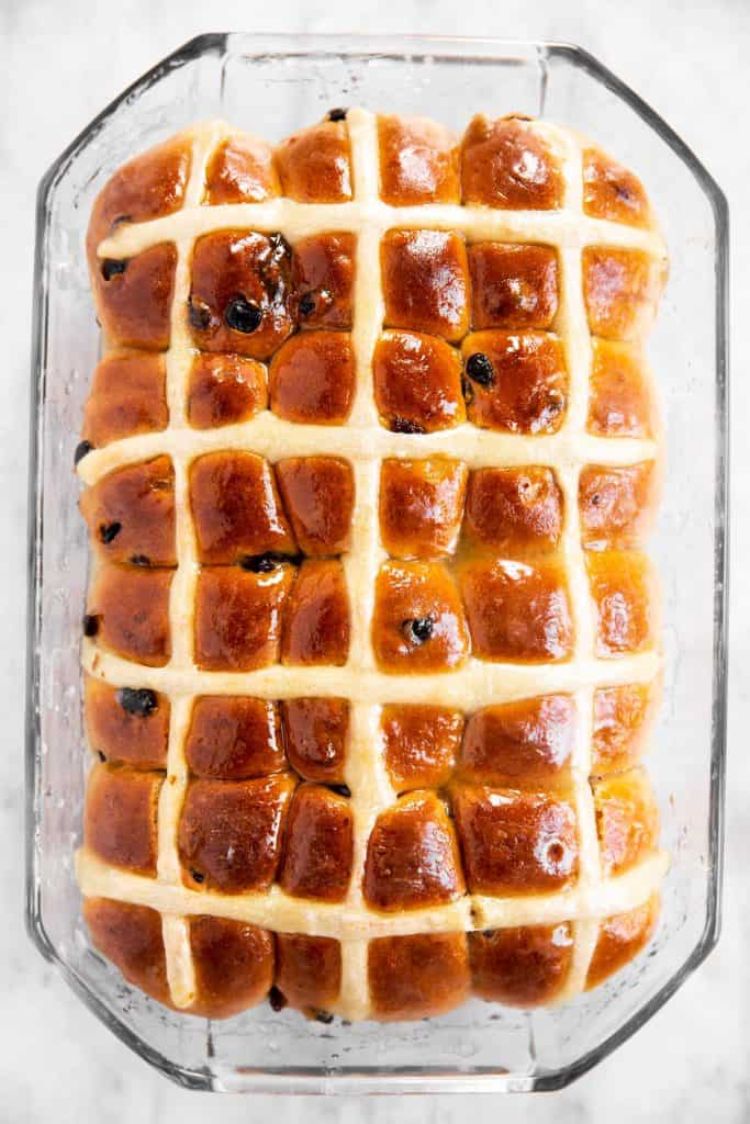 freshly baked and glazed hot cross buns in glass pan