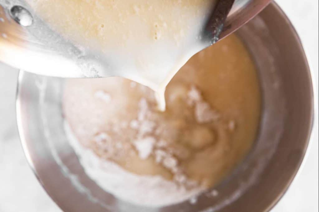 pouring liquid ingredients into bowl with flour