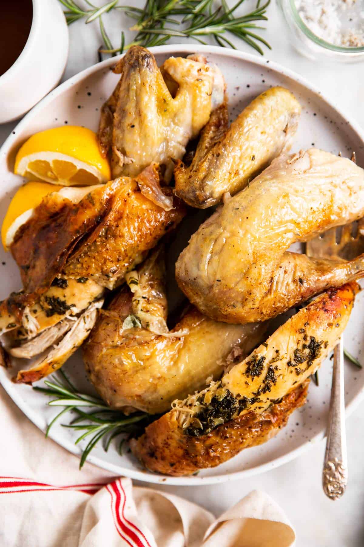 carved chicken pieces from a whole roasted chicken on a white plate