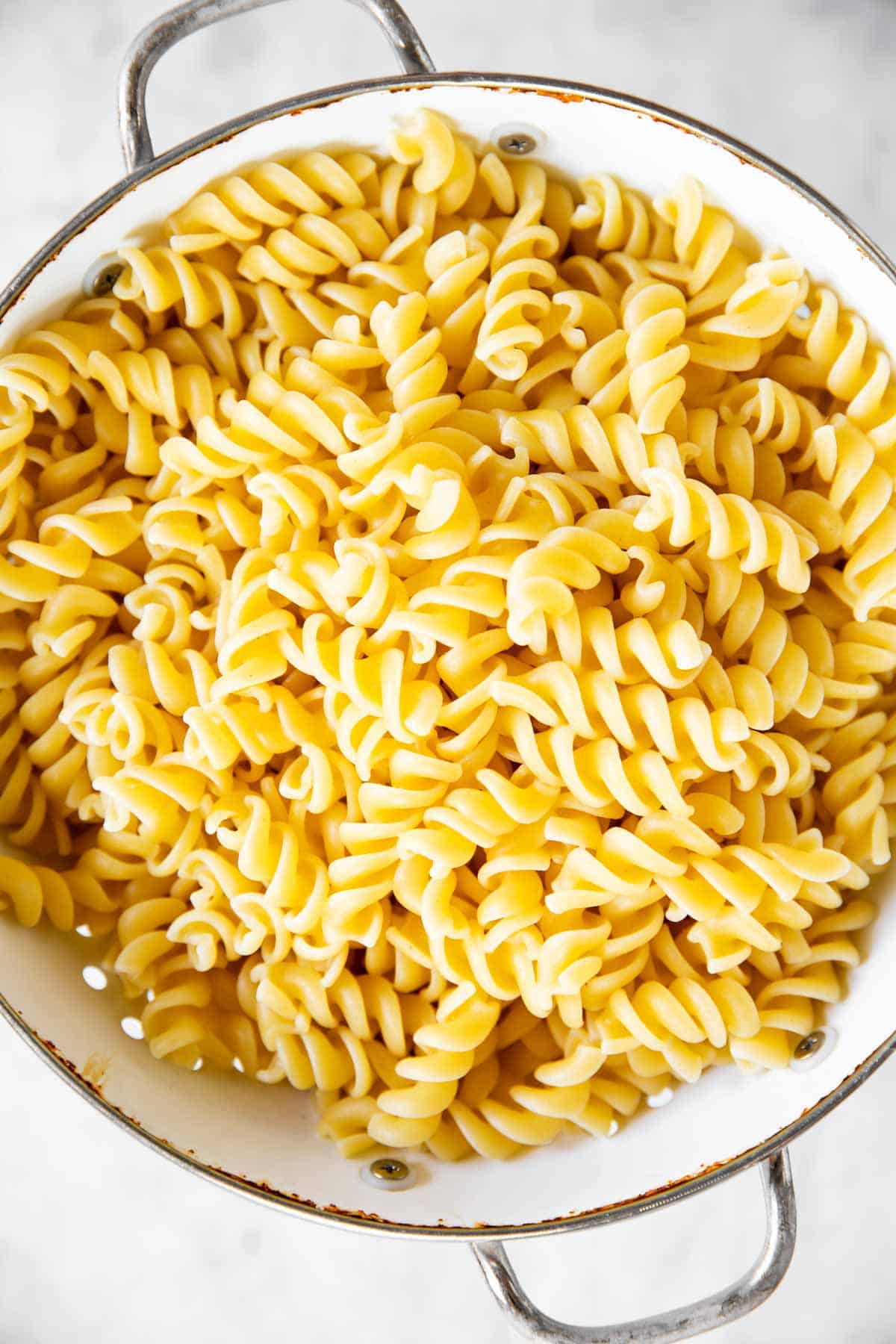 cooked pasta in white colander