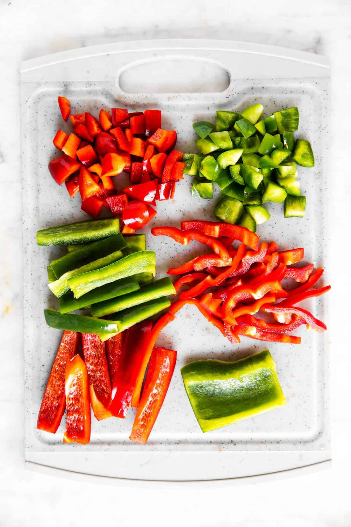 grey chopping board with red and green sliced bell pepper