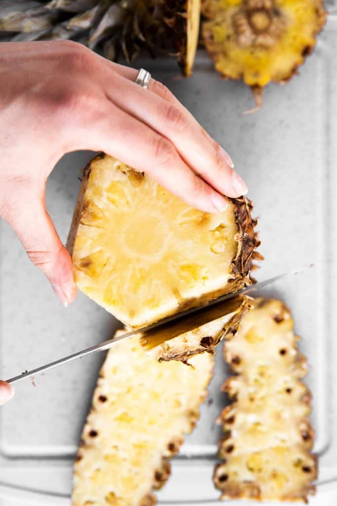 female hand peeling a pineapple