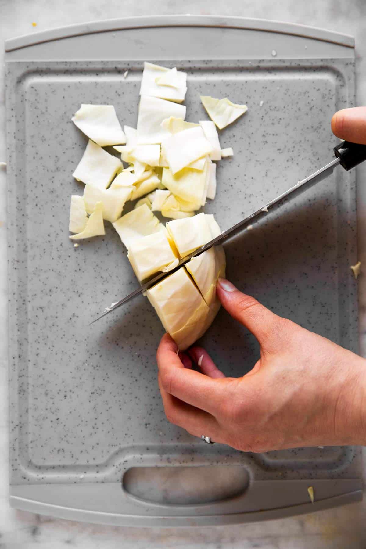 female hands dicing white cabbage