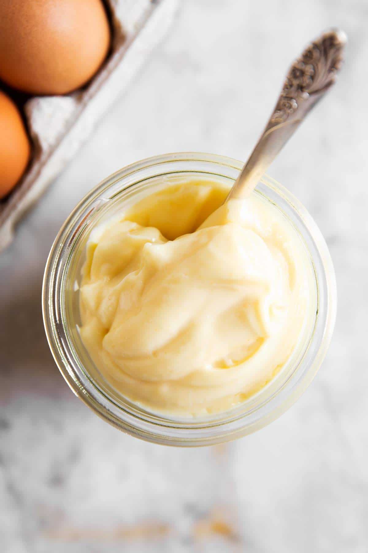 overhead view of mayonnaise un a glass jar with spoon stuck inside
