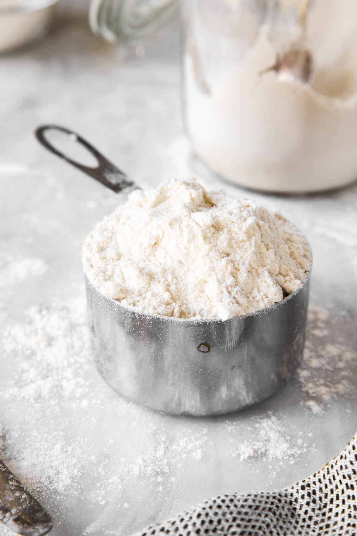 frontal view of measuring cup piled with flour