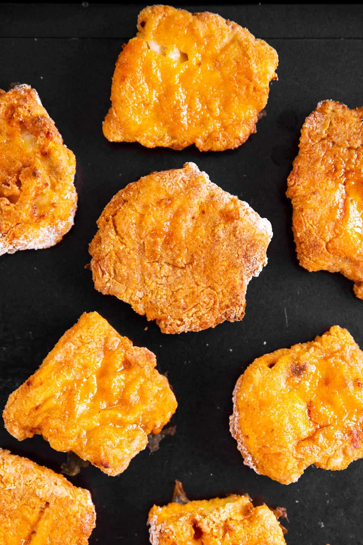 close up photo of oven fried fish on black pan